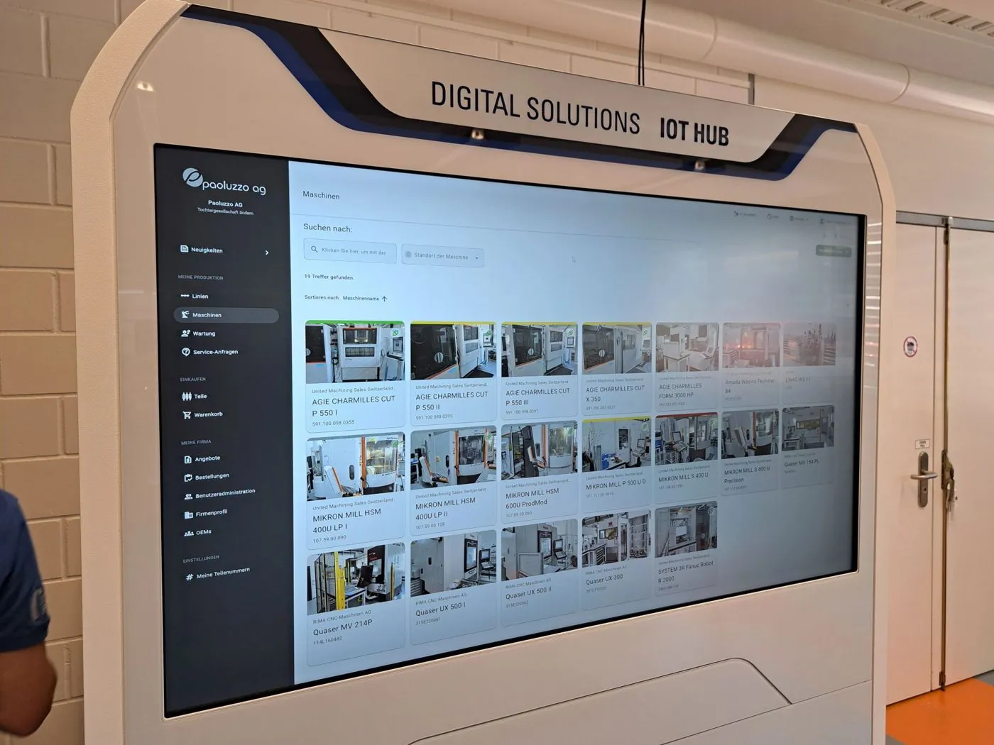 Der IoT Hub von Transaction-Network in einer Fertigungshalle, auf dem Bildschirm die Maschinen des Werks